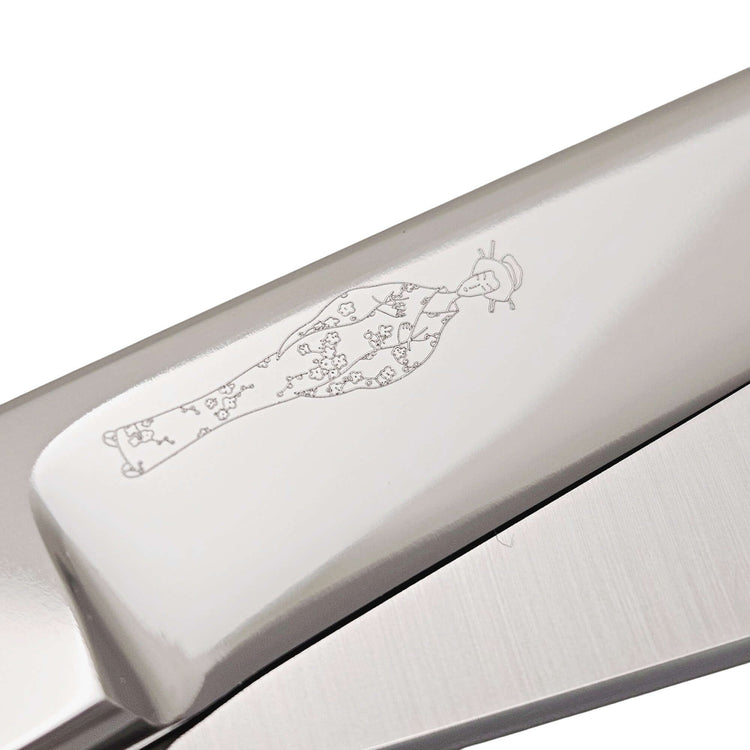 Professional Japanese hair cutting shears close-up showing detailed engraving on the handle.