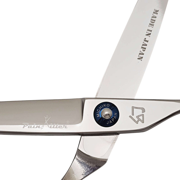 Close-up of a pair of scissors with 'Made in Japan' and brand logos on a white background