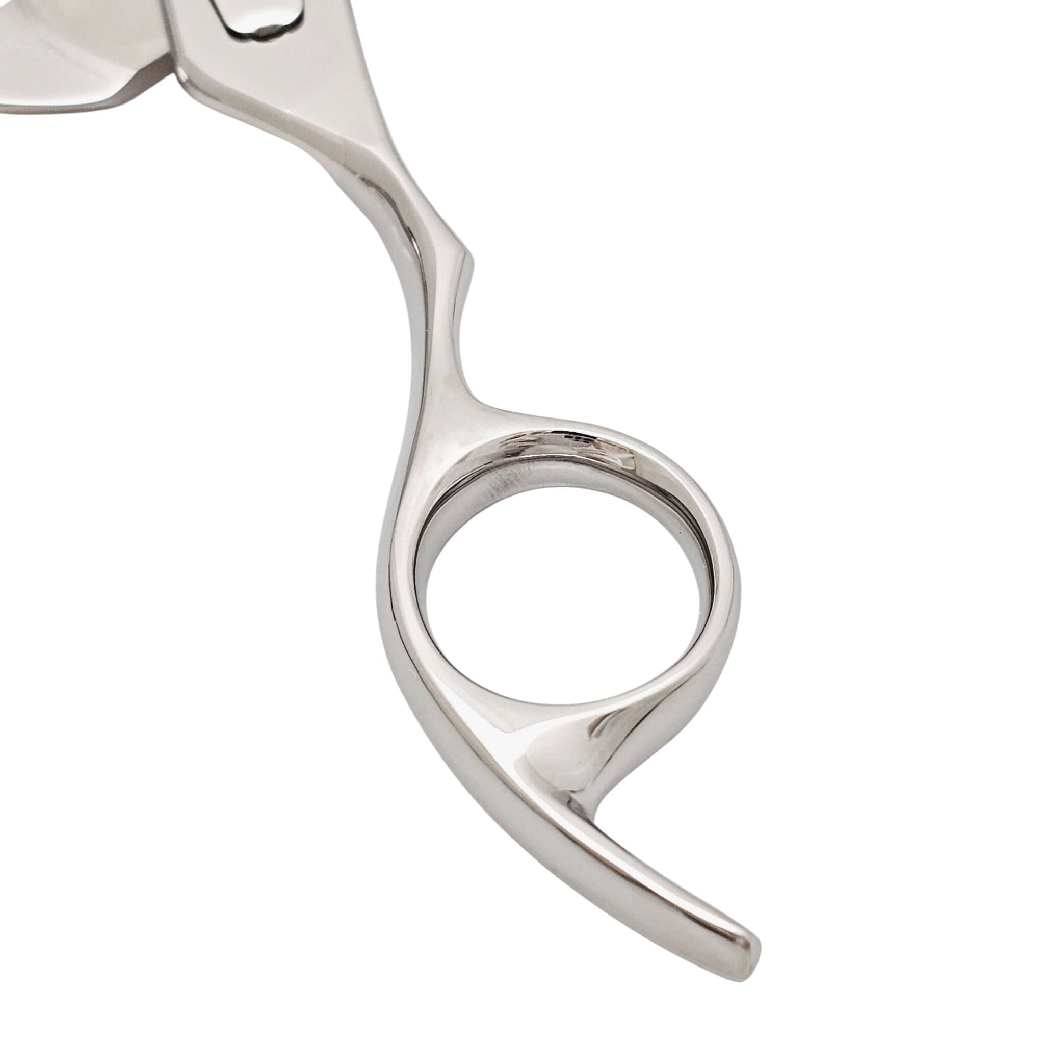 Close-up of a silver finger ring of hair scissors on a white background