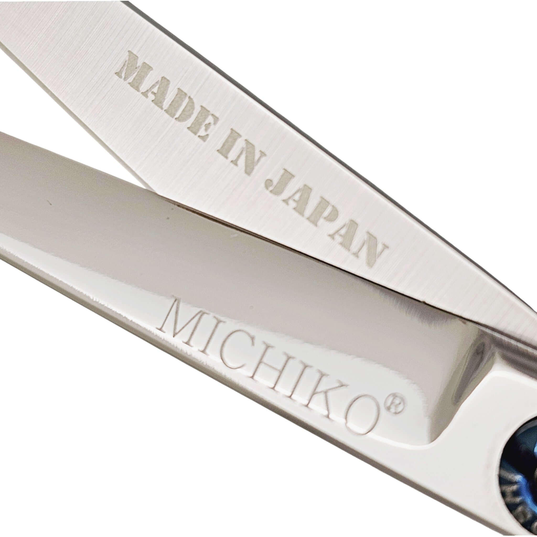 Close-up of hair scissors blades with 'MADE IN JAPAN' and 'MICHIKO' branding on a white background.