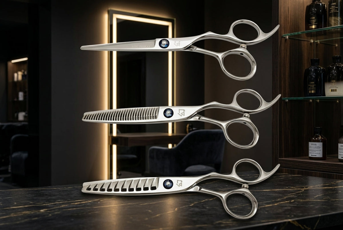 Three professional Michiko hair shears displayed in a high-end salon with dark mood lighting and warm illuminated mirror accents.