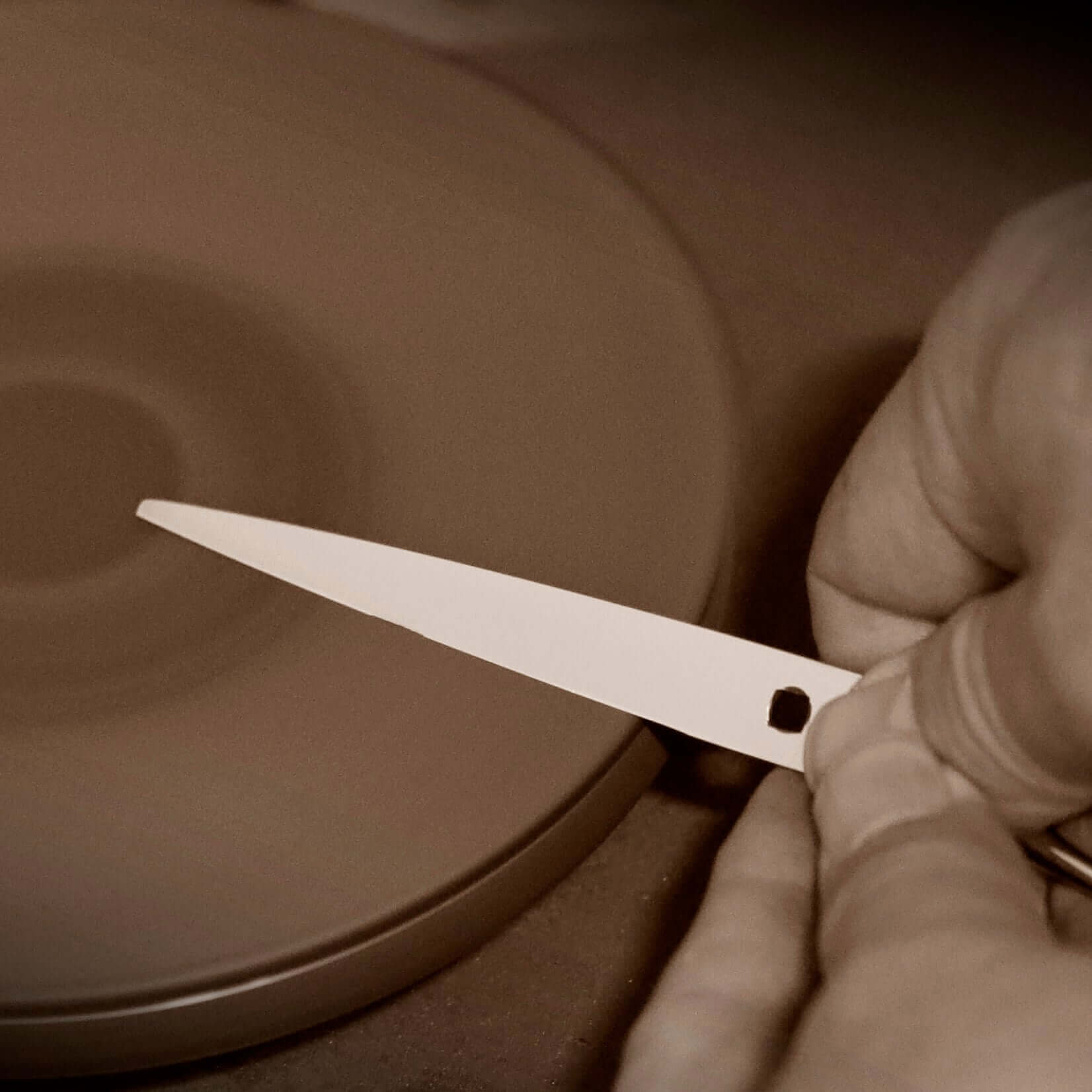 Professional sharpener honing a blade on a sharpening machine to achieve a precise convex edge.
