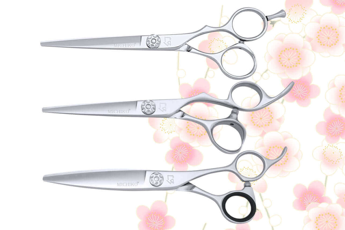 Premium Michiko hair cutting scissors – ergonomic Japanese-style professional shears with offset handles, crane design, and precision tension dial, displayed on a floral background for hairstylists and salon professionals.