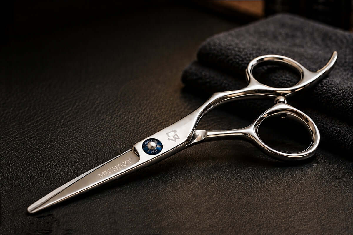 A close-up of professional shears on dark fabric.