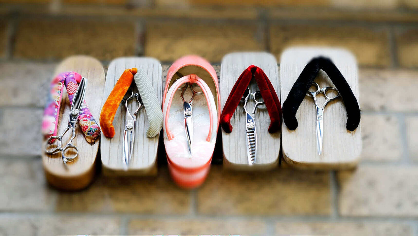 High-end Japanese hair cutting scissors displayed creatively on traditional geta sandals with vibrant fabric straps, blending craftsmanship with cultural elegance.