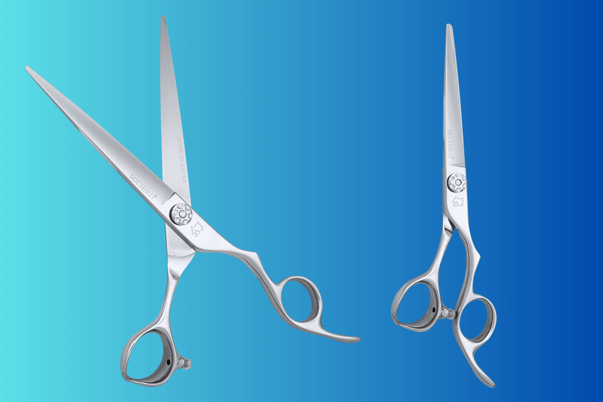 Two hair cutting scissors side by side on a blue background