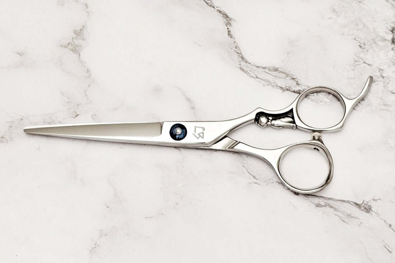 Cat design handle hair cutting scissors on a marble surface