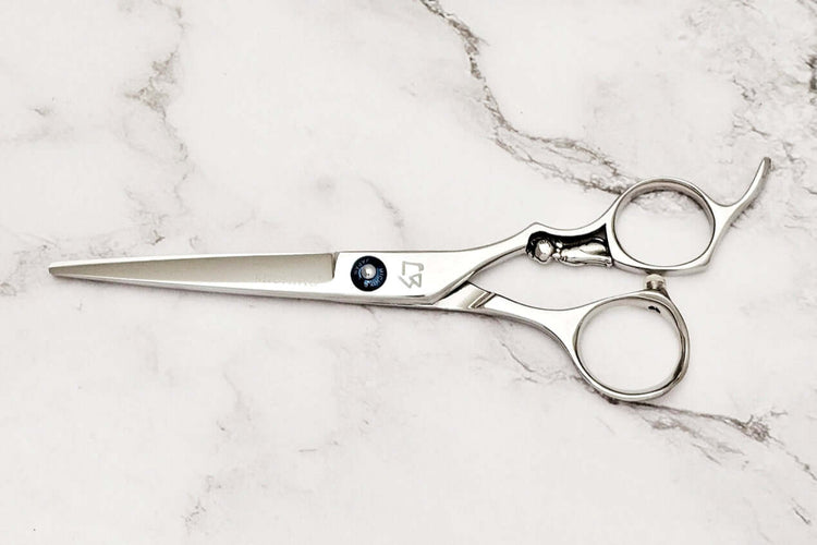 Cat design handle hair cutting scissors on a marble surface