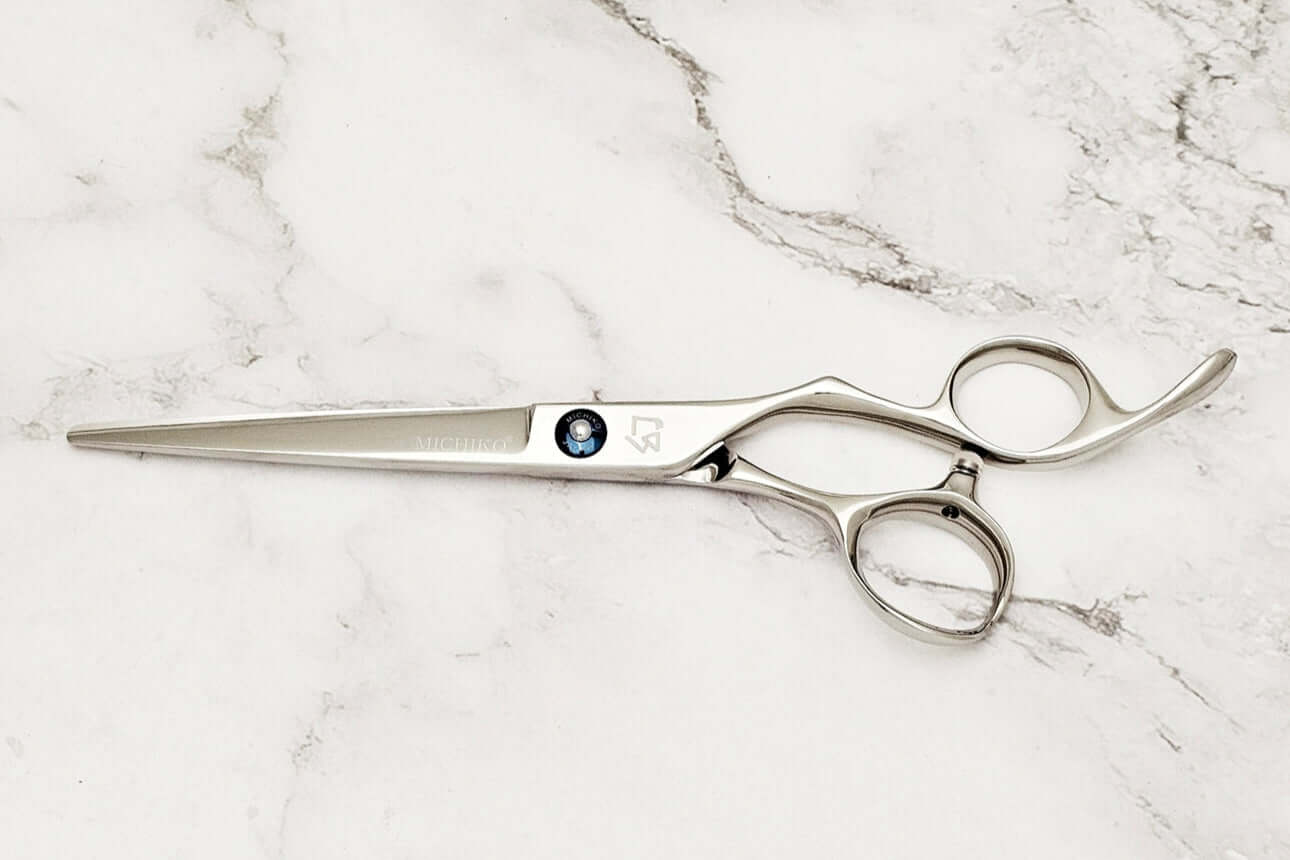 KM 6.5" barber shears on a marble surface.