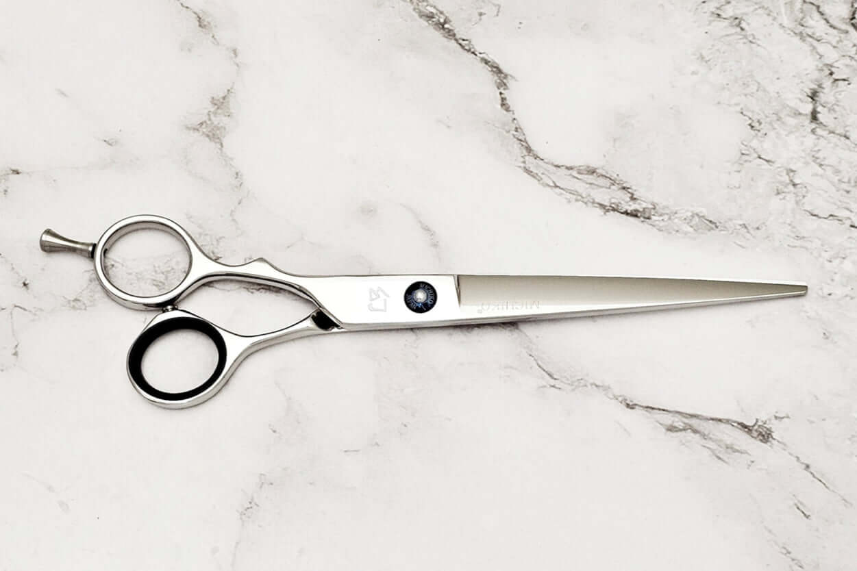 Lefty hair cutting scissors on a marble surface