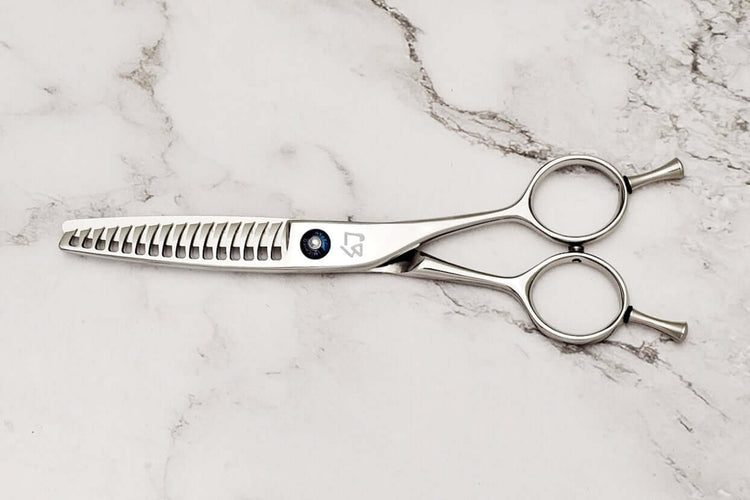Reversible hair texturizing shears on a marble surface