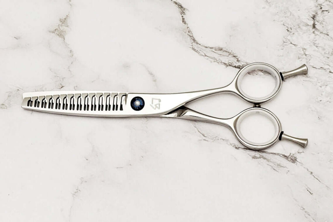 Hair texturizing shears on a marble surface