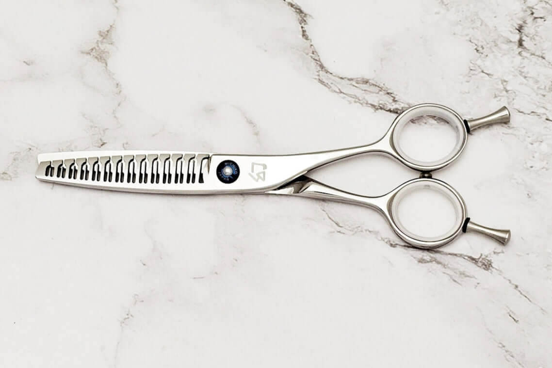 Hair texturizing shears on a marble surface