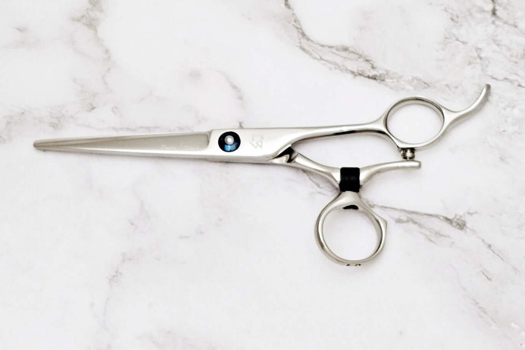 Swivle hair cutting scissors on a marble background