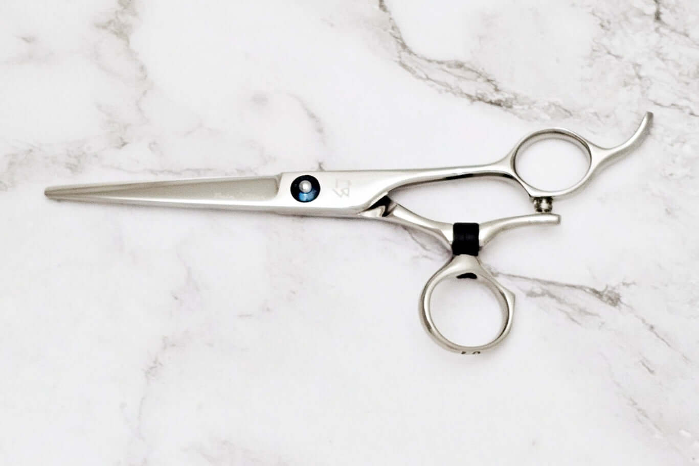 Swivle hair cutting scissors on a marble background