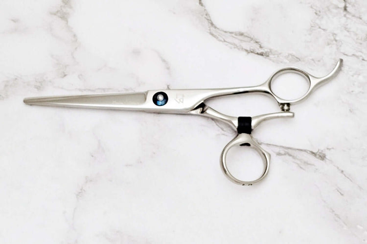 Swivle hair cutting scissors on a marble background