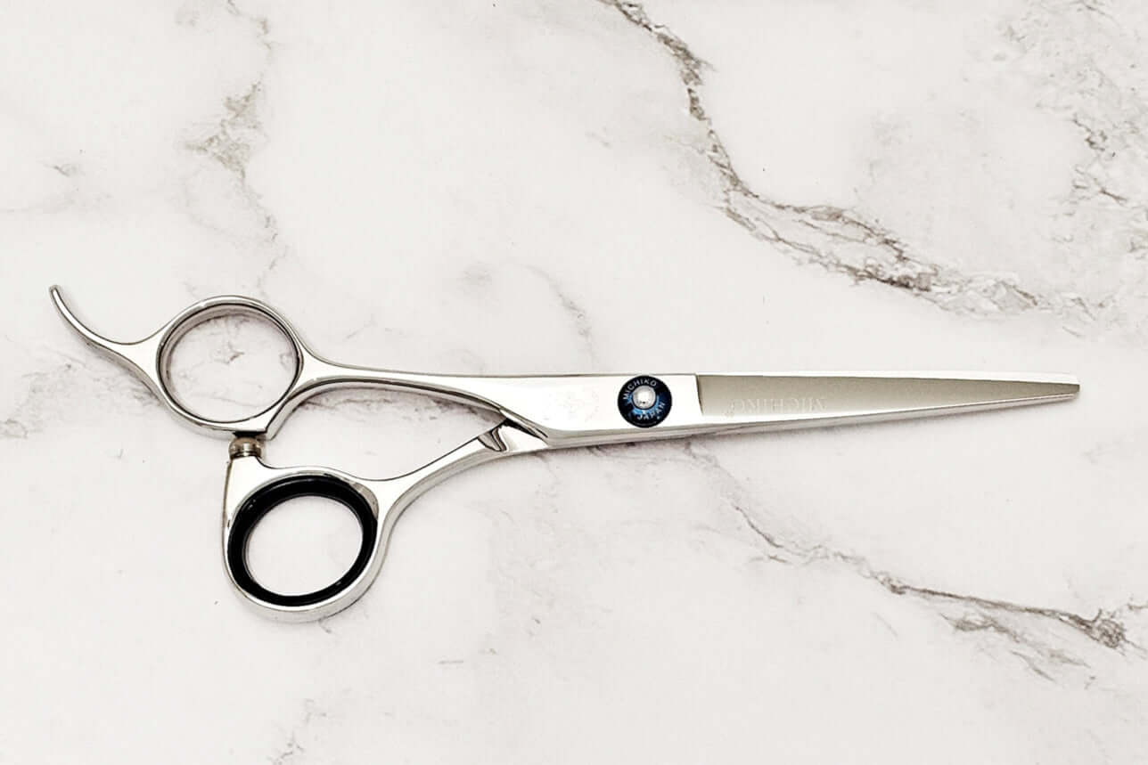 Lefty hair cutting scissors on a marble surface