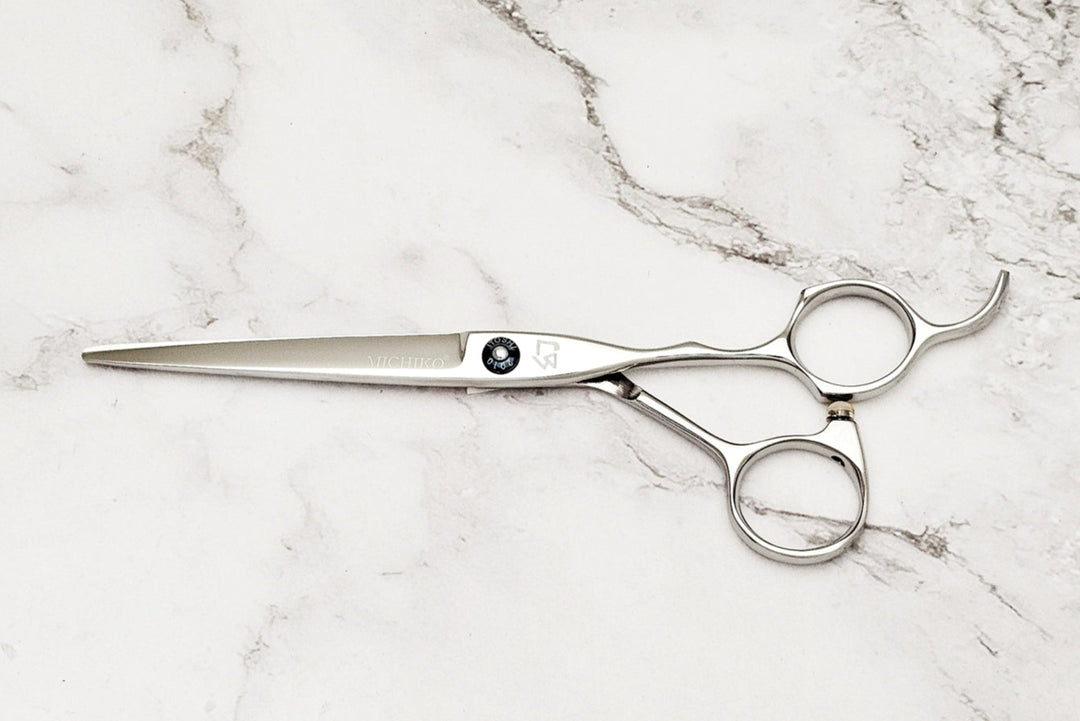 Pair of hair scissors on a marble surface