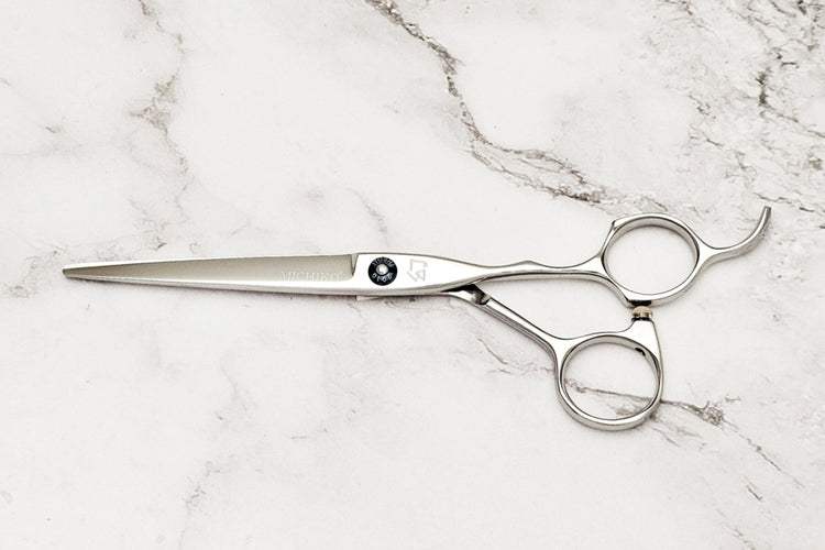 Pair of hair scissors on a marble surface