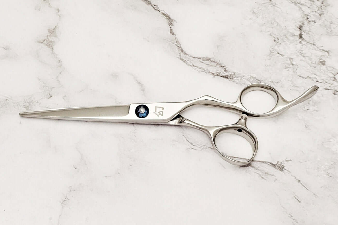KM 6.0 inch hair scissors on a marble surface