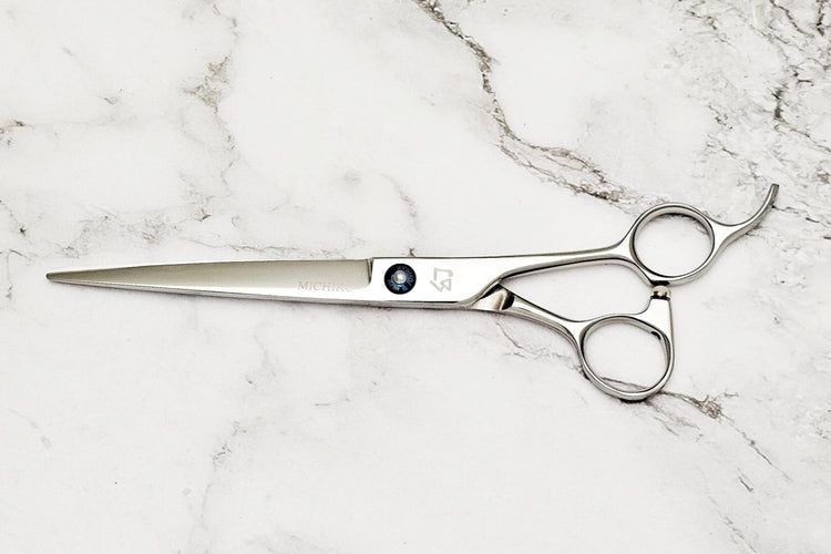 Barber shear on a white marble background