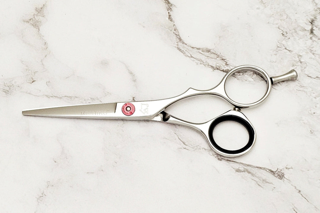 Precision hair cut scissors on white marble background