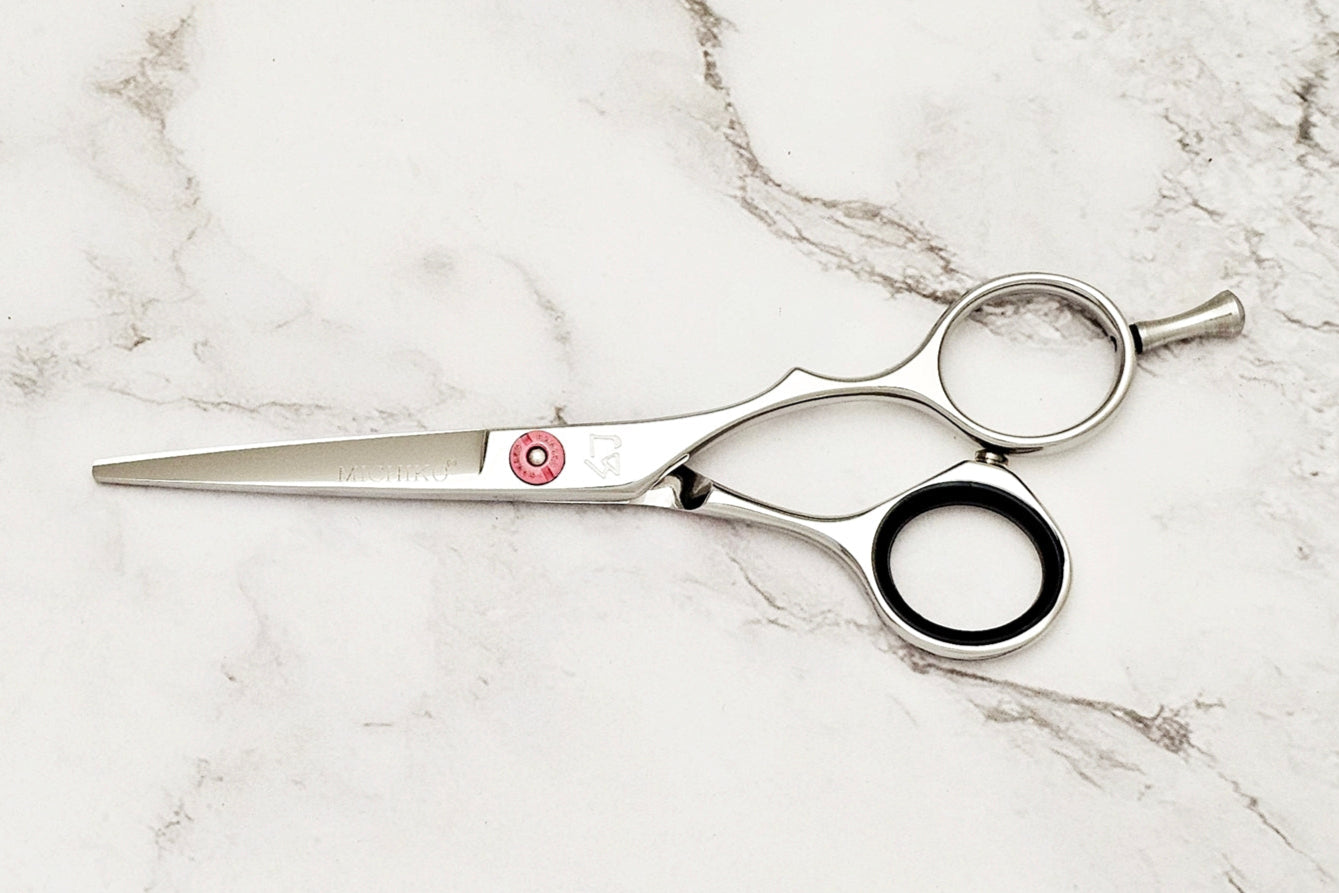 Precision hair cut scissors on white marble background