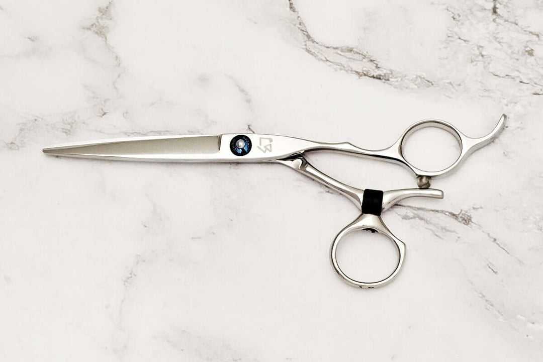 Swivel hair cutting scissors on a marble background