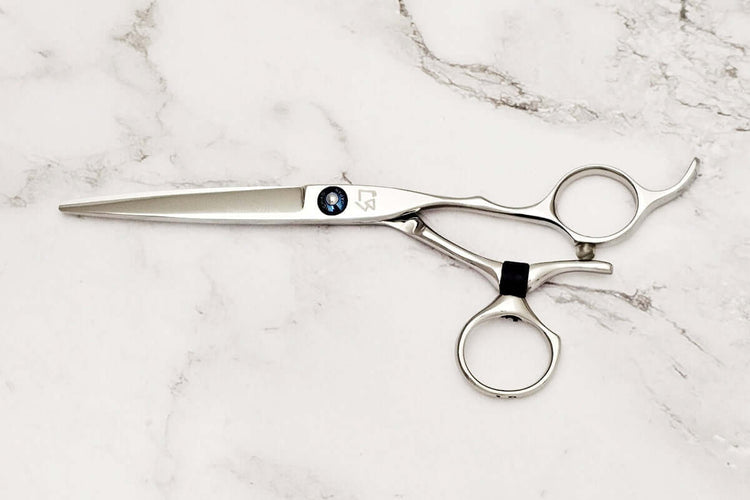 Swivel hair cutting scissors on a marble background