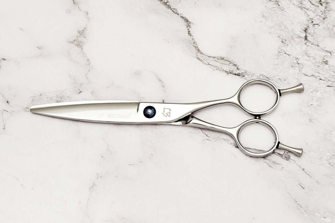 Slide cutting hair scissors on a marble surface