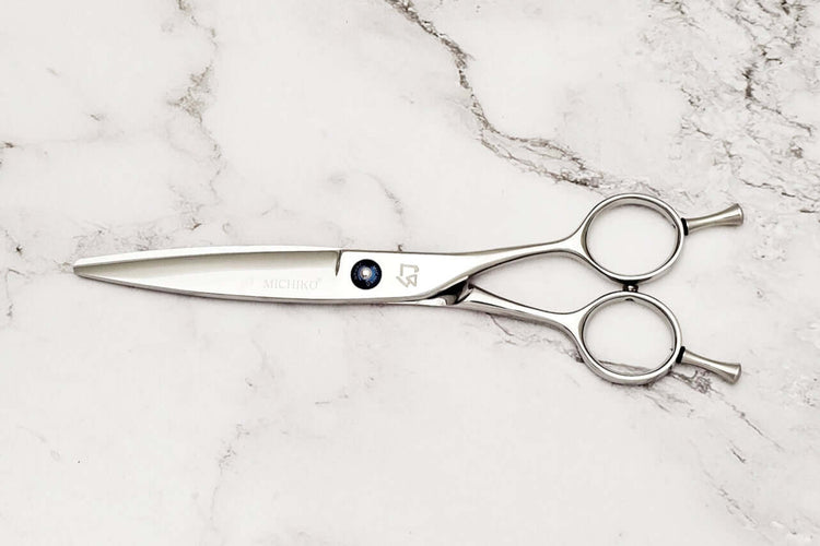 Slide cutting hair scissors on a marble surface