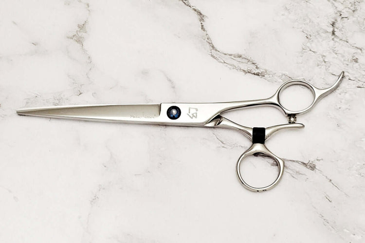 Swivel barber shears on a marble surface