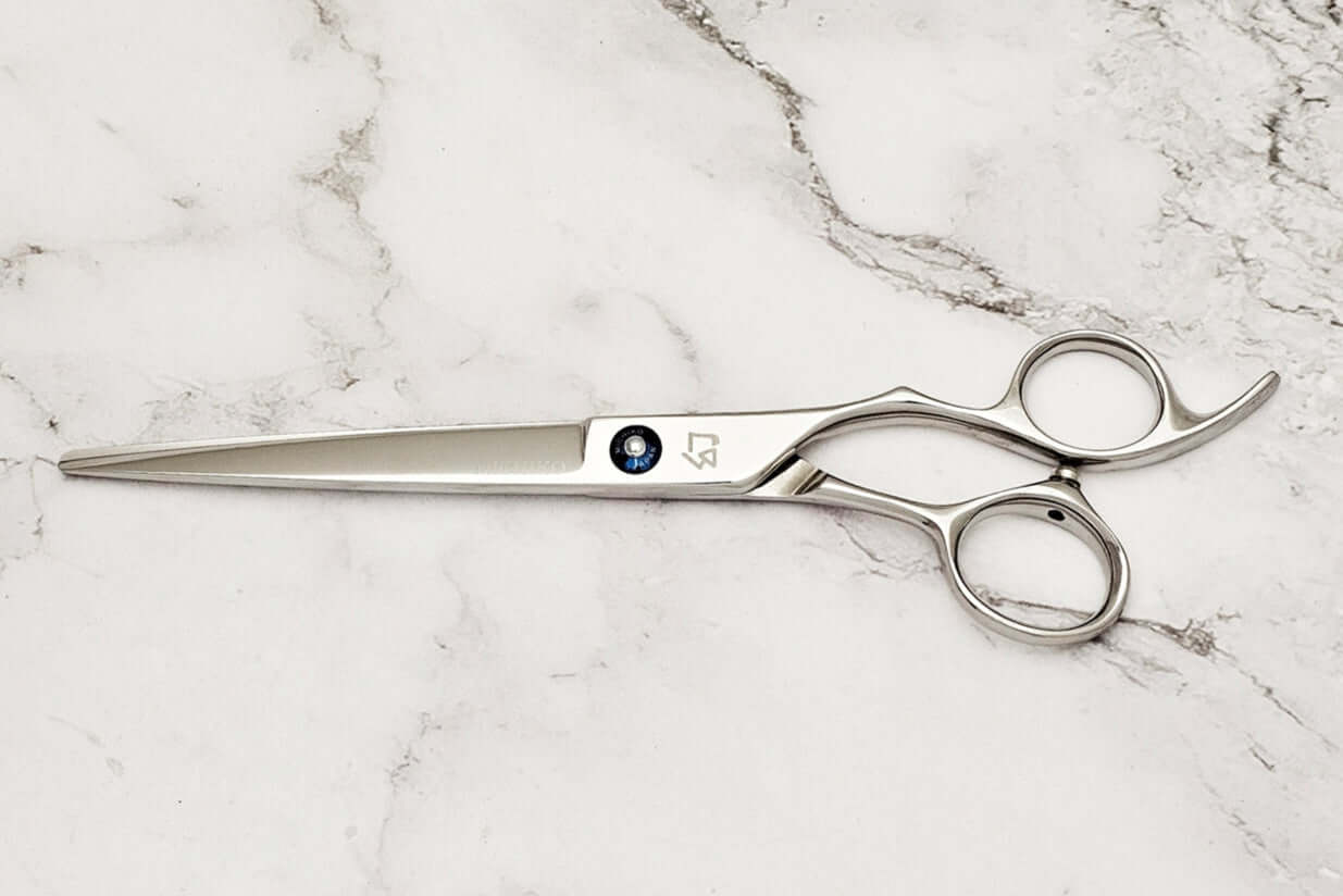 Cobalt alloy hair cutting shears on a marble surface