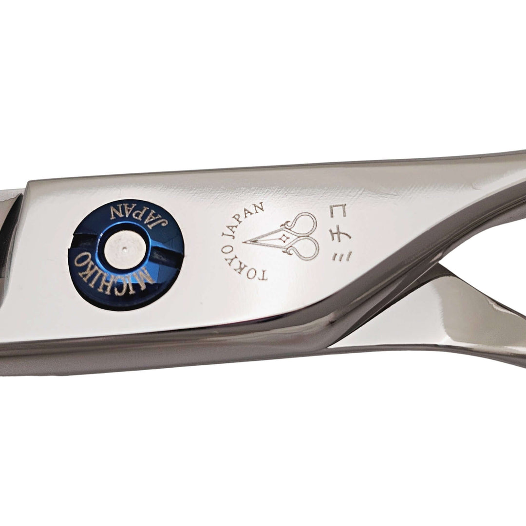 Close-up of a hairdressing shear with 'Michiko' branding on a white background