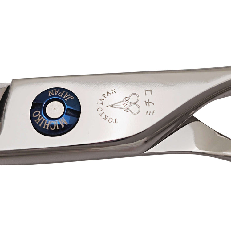 Close-up of a hairdressing shear with 'Michiko' branding on a white background