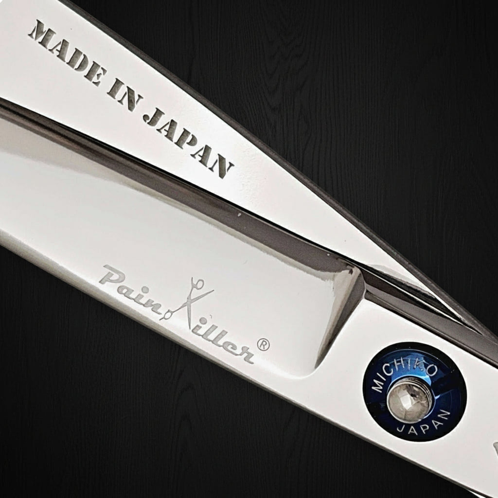 Close-up of a pair of hair scissors with 'Made in Japan' and 'PainKiller' branding on a white background.