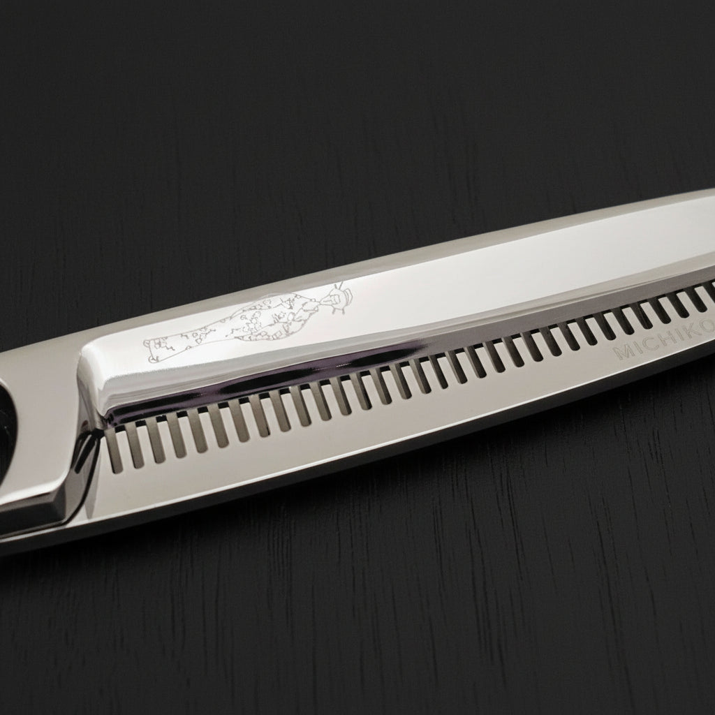 Close-up of hair thinning shears with engraved Japanese lady design on a white background