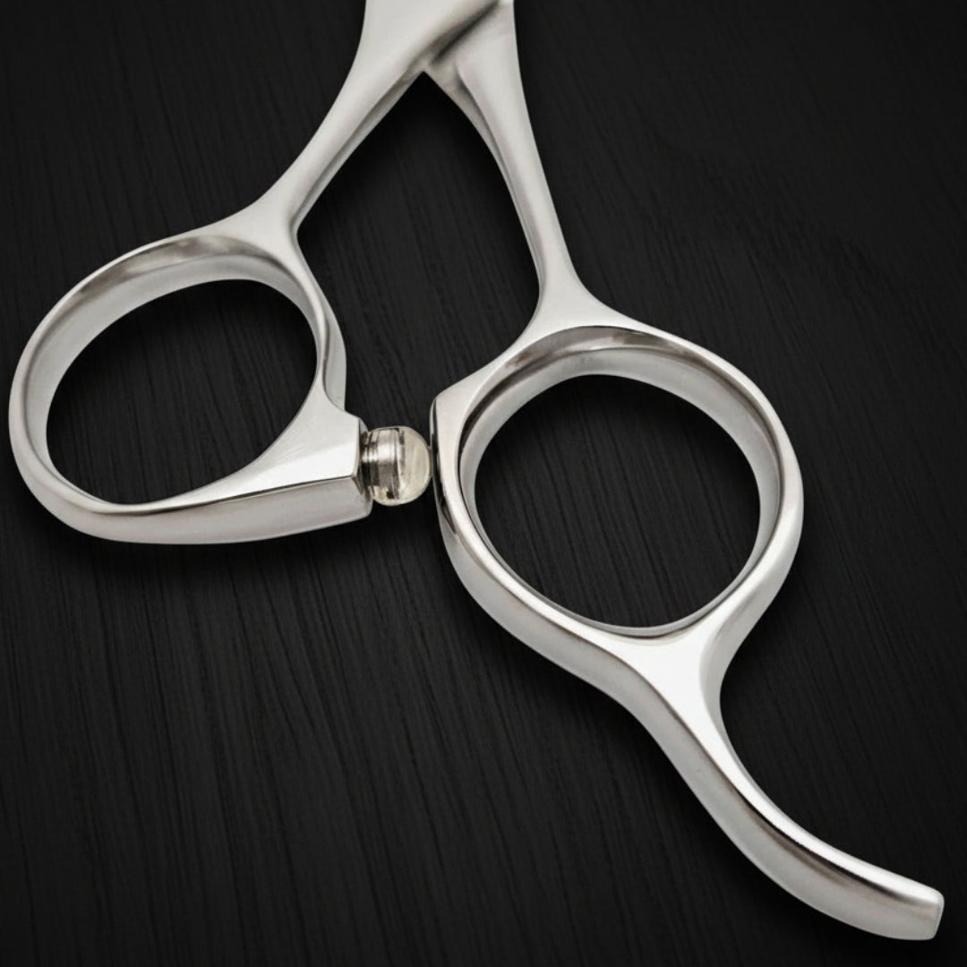 Close-up of a pair of silver hair scissors handle on a white background