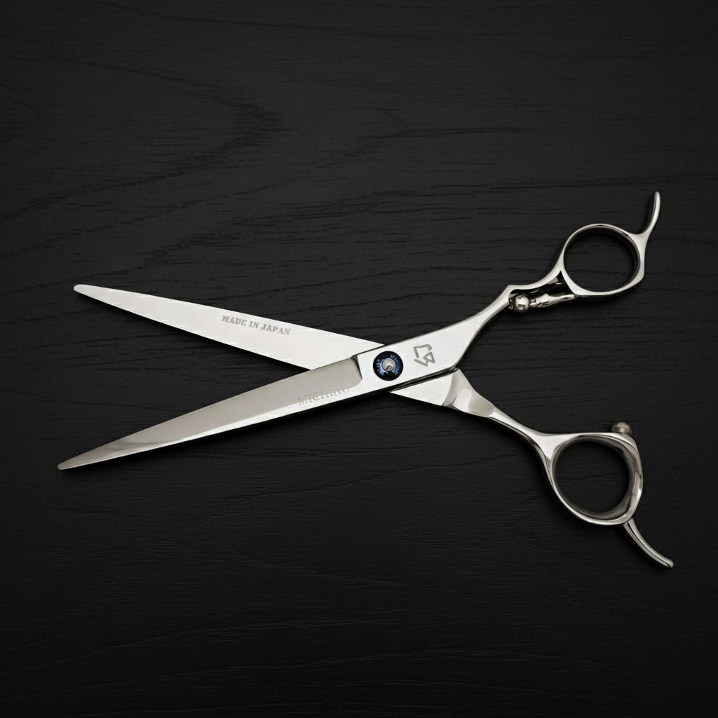 Stainless steel hair cutting scissors with a kitten engraved on handle on a white background