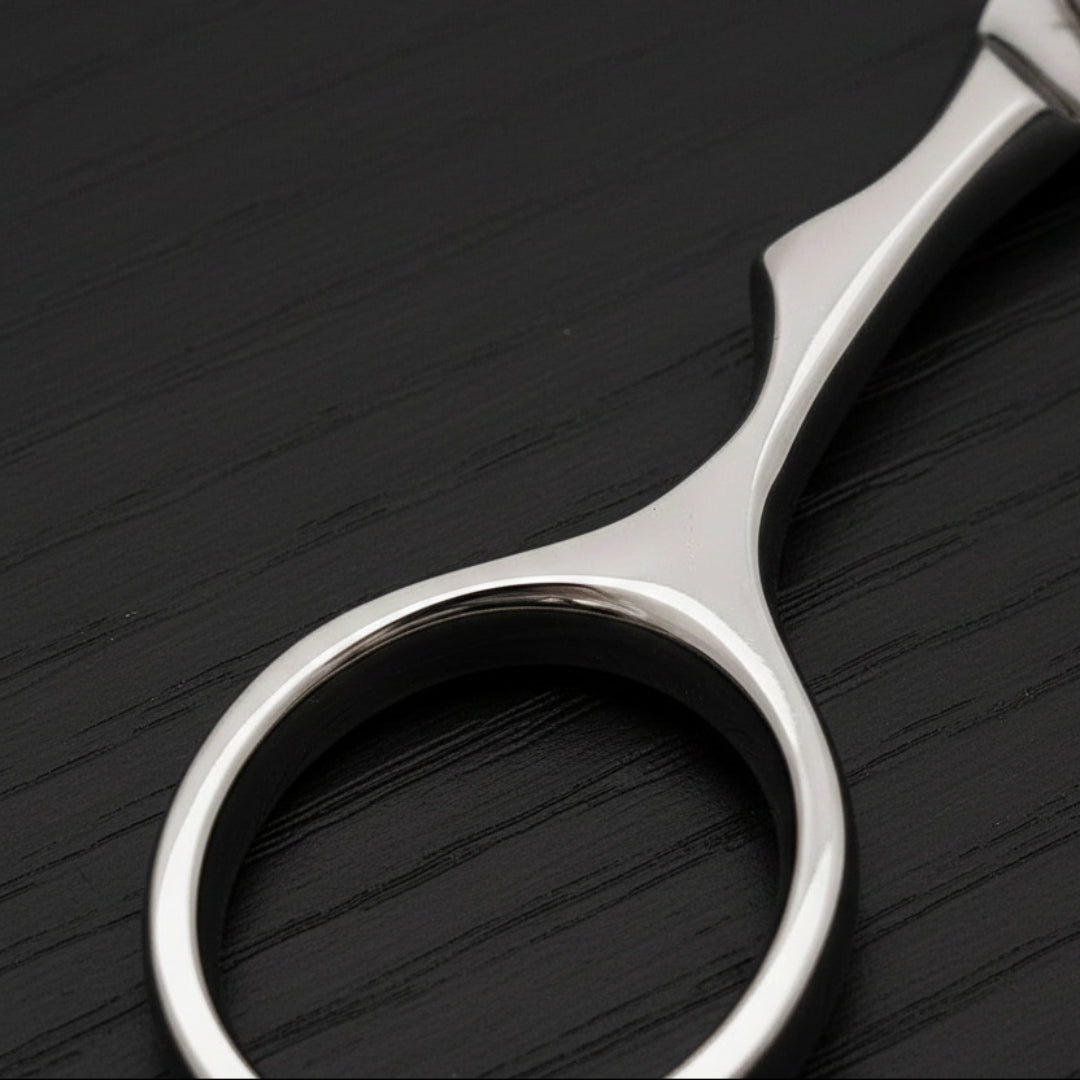 Close-up of a pair of silver scissors finger ring on a white background