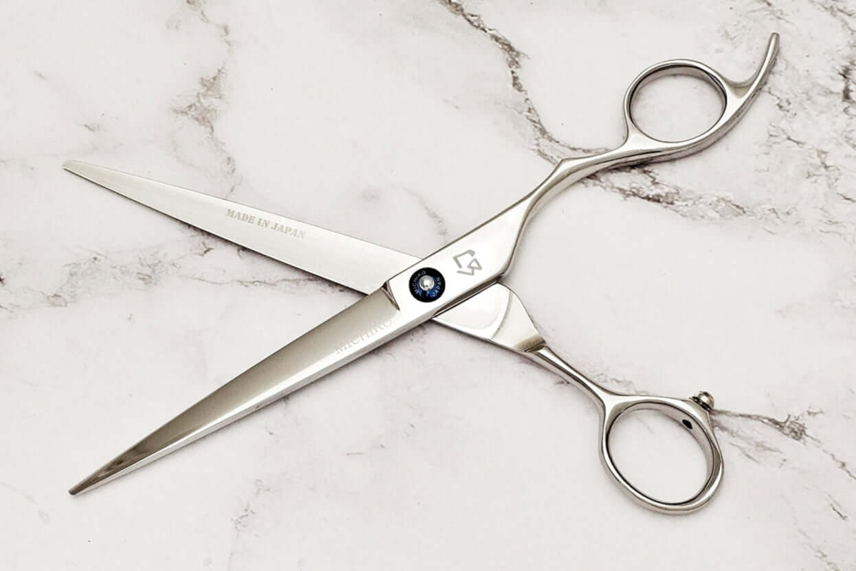 Cobalt alloy hair cutting shears on a marble surface