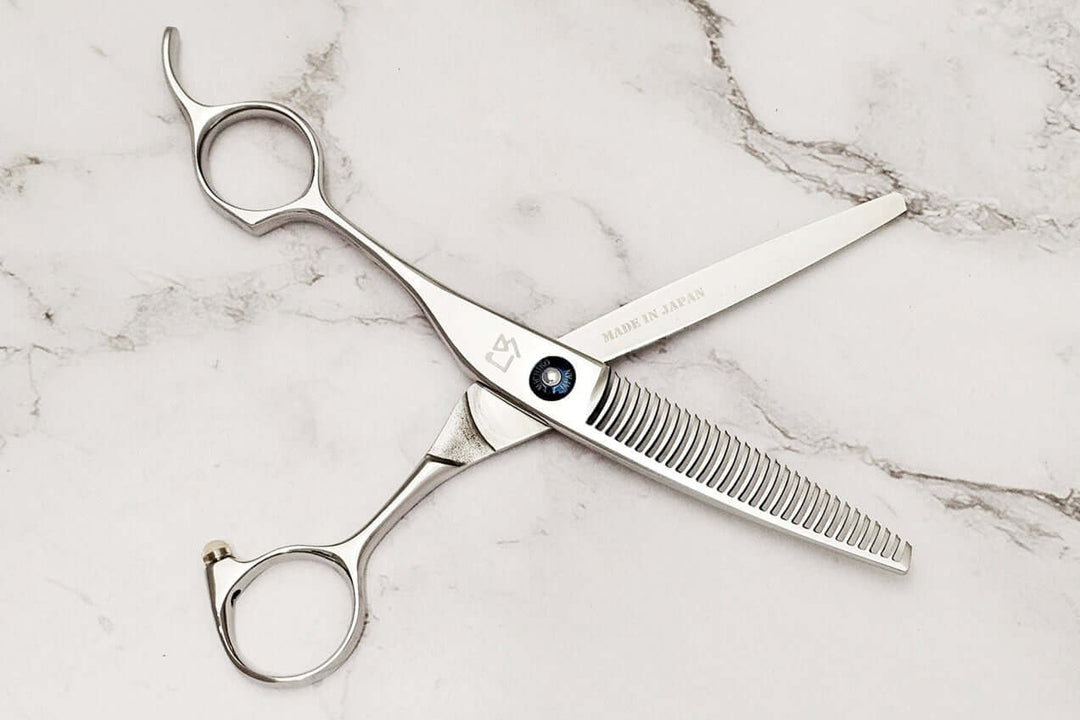 Left-handed hair-thinning scissors on a marble surface