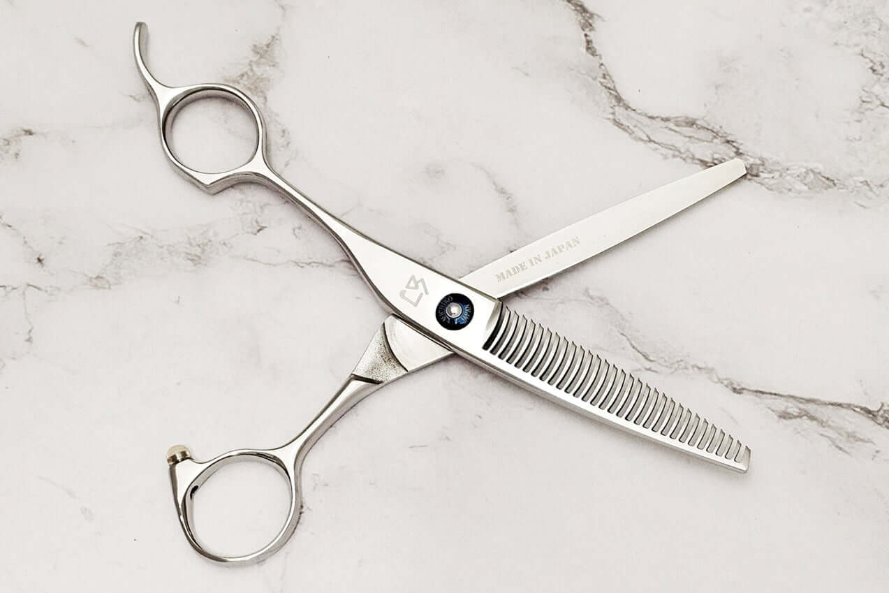 Left-handed hair-thinning scissors on a marble surface