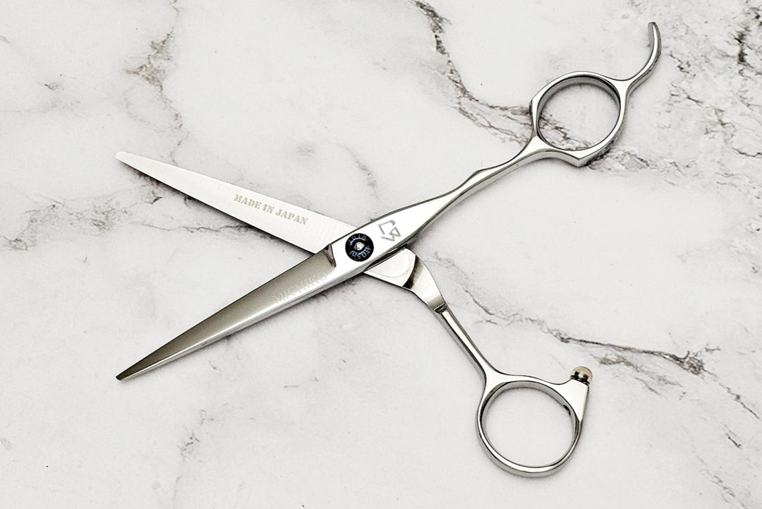 Pair of hair scissors on a marble surface