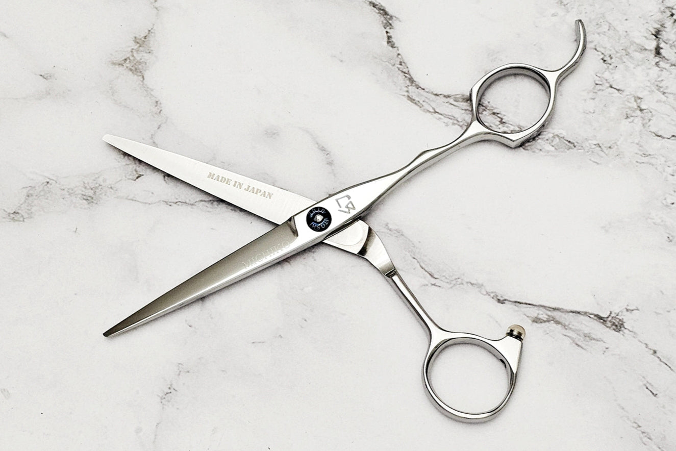 Pair of hair scissors on a marble surface