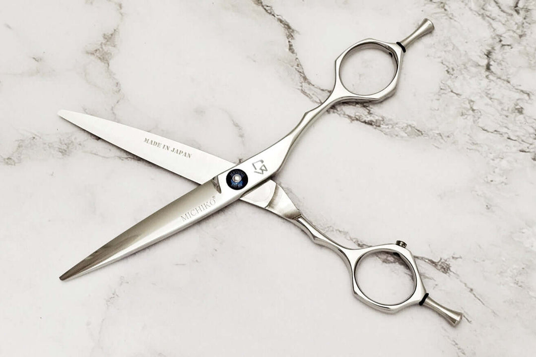 Pair of hair scissors on a marble surface