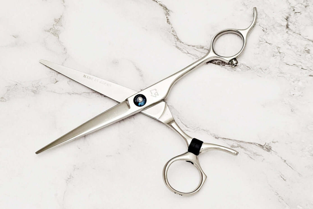 Swivle hair cutting scissors on a marble background