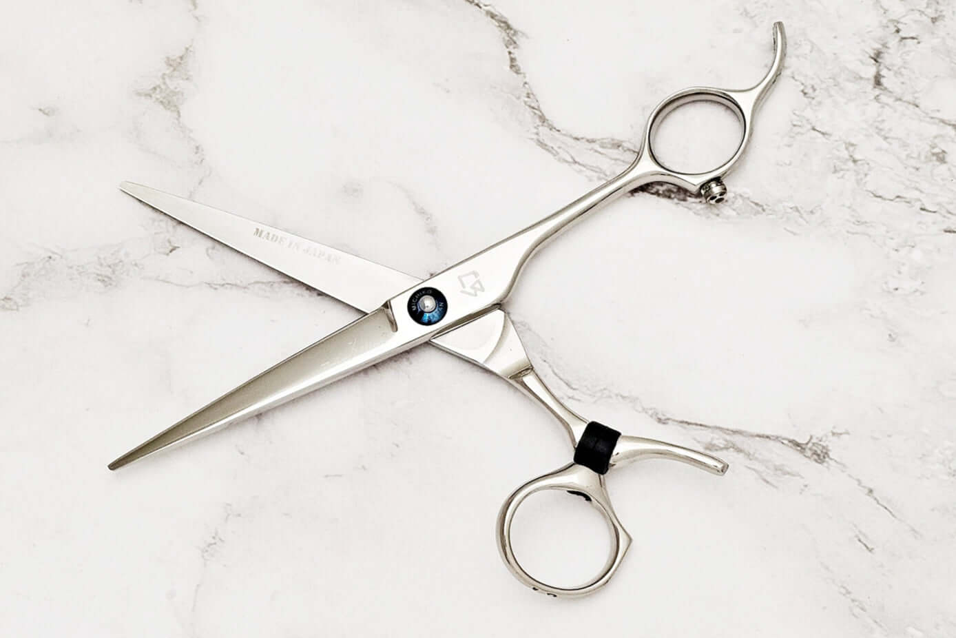 Swivle hair cutting scissors on a marble background