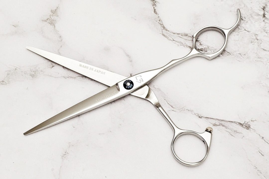 Pair of hair scissors on a marble surface