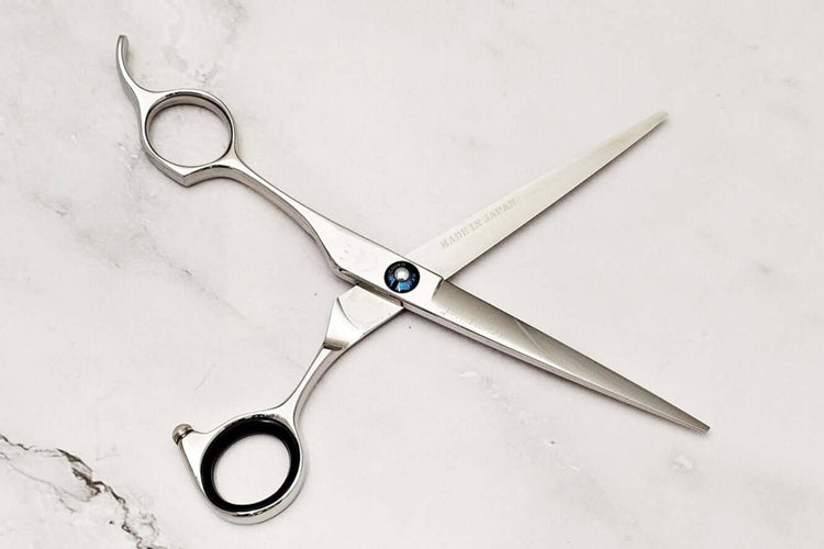 Lefy hair cutting scissors on a marble surface